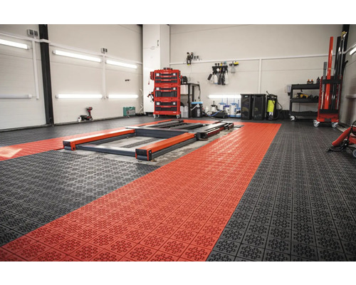 Dílna s modulární podlahovou krytinou v černé a červené barvě a zvedací plošinou
