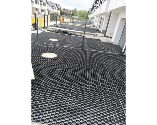 Scéna s položenými zatravňovacími dlaždicemi na pozemku.