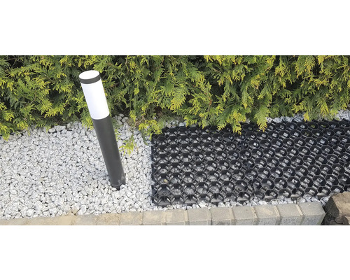 Scéna s travní mřížkou, okrasným štěrkem, venkovním světlem a živým plotem