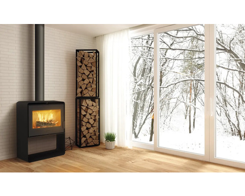 Obývací pokoj s krbovými kamny, regálem na dřevo a výhledem na zasněžené stromy