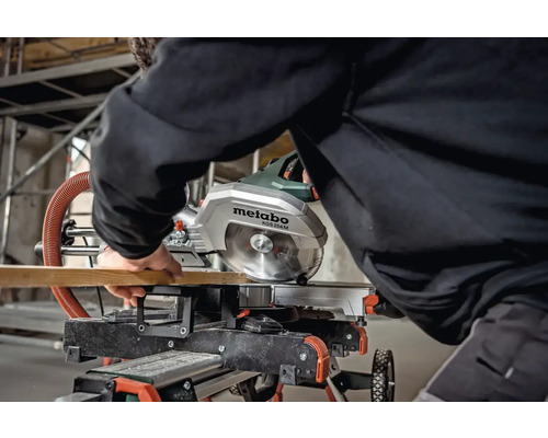 Pokosová pila Metabo KGS 254 M řeže dřevěnou desku.