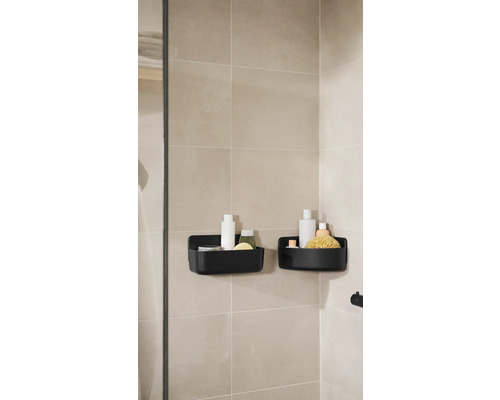 Dva černé sprchové koše s koupelnovými potřebami na stěně koupelny