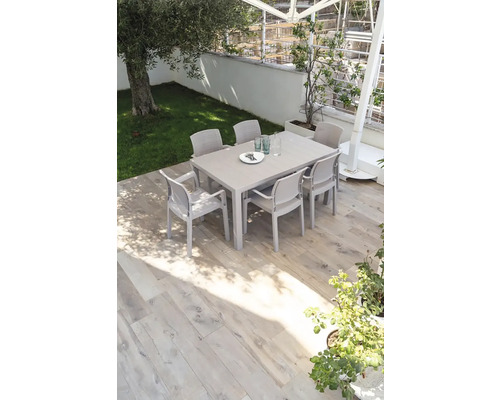 Zahradní scéna s jídelním stolem a židlemi venku na terase.