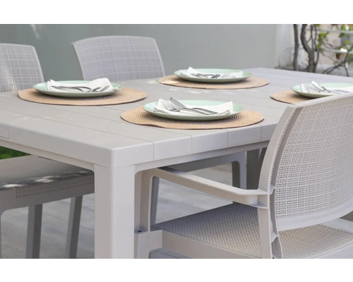 Jídelní stůl se čtyřmi prostíráními a židlemi na zahradu nebo terasu