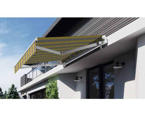 Vysunutá kloubová markýza s pruhovanou markýzou na domě