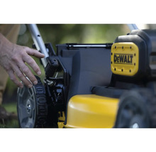 Detailní pohled na žlutou sekačku na trávu značky DeWalt s ovládacími prvky