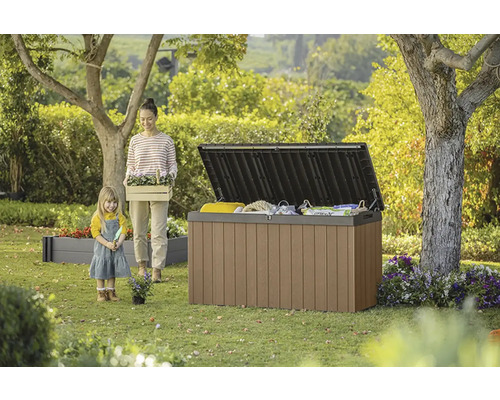 Zahradní scéna s otevřeným úložným boxem, ženou a dítětem.