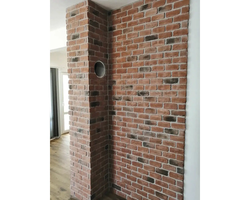Cihlová zeď v interiéru s kruhovým otvorem
