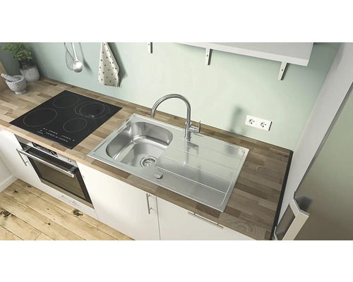 Kuchyňská scéna s dřezem, varnou deskou a troubou v kompaktním kuchyňském koutu