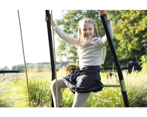 Dívka leze na zahradní houpačku pro děti