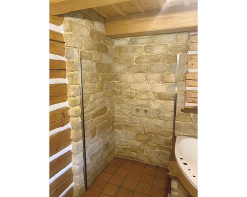 Koupelna s kamennými zdmi, sprchovým koutem a dlaždicovou podlahou
