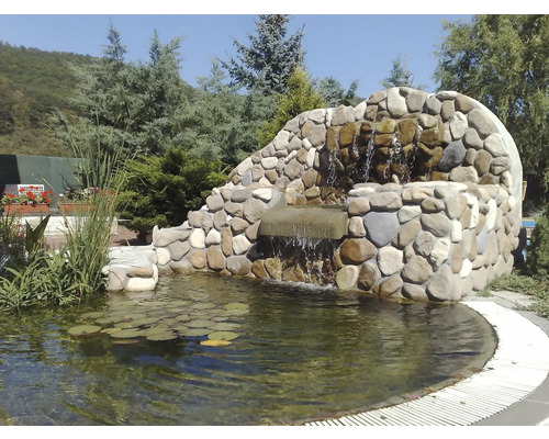 Zahradní jezírko s vodopádem a lekníny ve venkovním prostředí