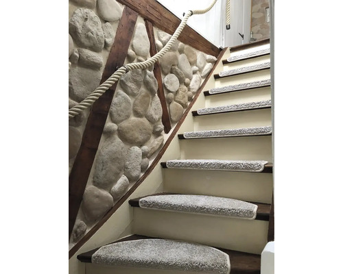 Schodiště s podložkami na schody a lanovým zábradlím před kamennou zdí