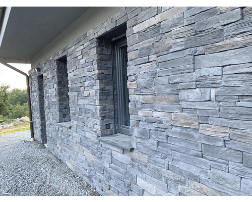 Fasáda domu s kamenným obkladem a okny