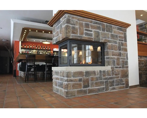 Interiérová fotografie místnosti s barem a kamenným krbem