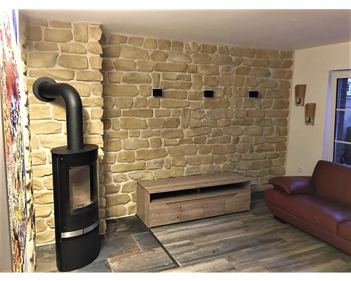 Obývací pokoj s kamenným krbem, kamennou zdí a dřevěným nábytkem pro útulnou atmosféru.