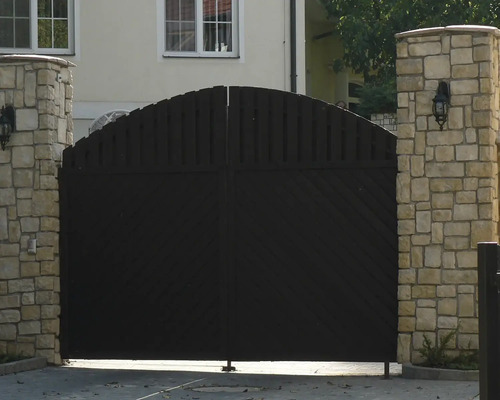 Tmavá dřevěná brána s kamennými sloupky