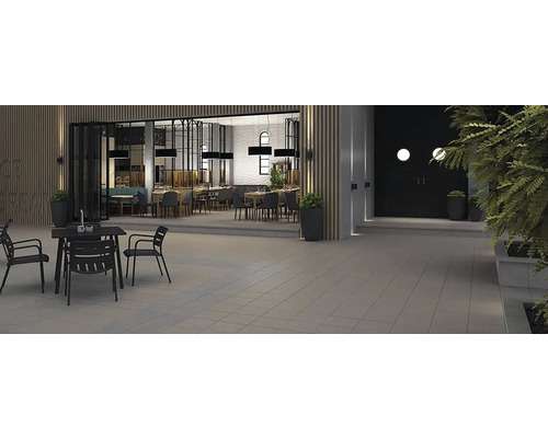 Venkovní prostor restaurace s terasovými dlaždicemi a zahradním nábytkem.