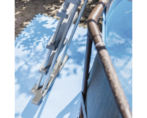 Bazénový žebřík a bazén na modrých bazénových rohožích