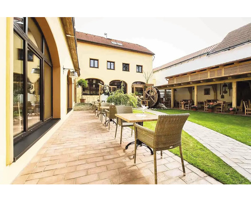 Venkovní prostor restaurace se stoly, židlemi, terasou a trávníkem