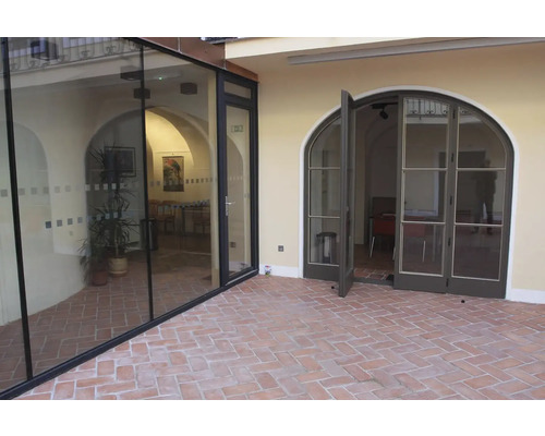 Venkovní pohled na budovu se skleněnými dveřmi a dvoukřídlými dveřmi