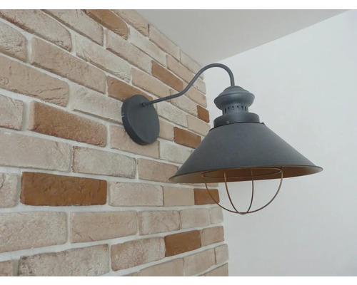 Nástěnné svítidlo v industriálním designu na cihlové zdi