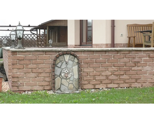 Vnější pohled na dům s cihlovou zdí a vodními prvky