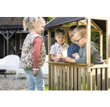 Děti si hrají v dřevěném domečku na zahradě.