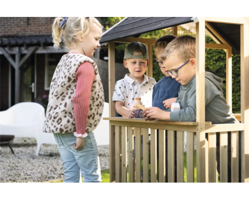 Děti si hrají v dřevěném domečku na zahradě.