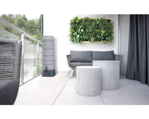 Moderní balkon s nádrží na dešťovou vodu, pohovkou, dvěma odkládacími stolky a zelenou stěnou