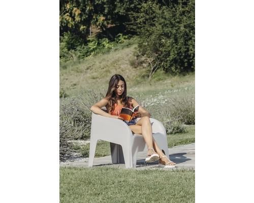 Žena čte knihu v zahradním křesle