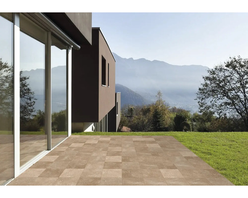 Terasa s dlaždicemi u moderního domu se zahradou a výhledem na hory