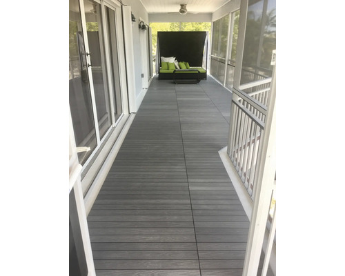 Veranda s terasovými deskami z dřevoplastu a zahradním nábytkem.