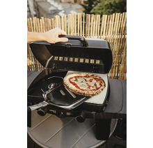 Příprava pizzy na plynovém grilu s pizza kamenem a lopatkou na pizzu.