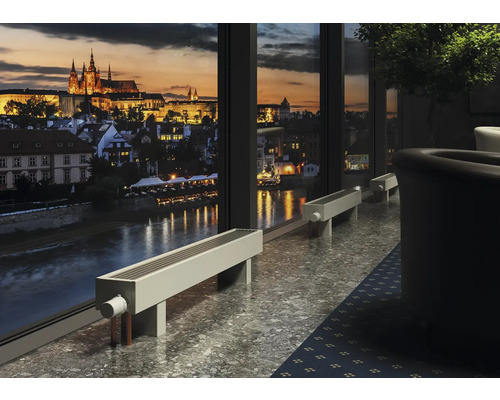 Interiér s radiátory před oknem s výhledem na město v noci