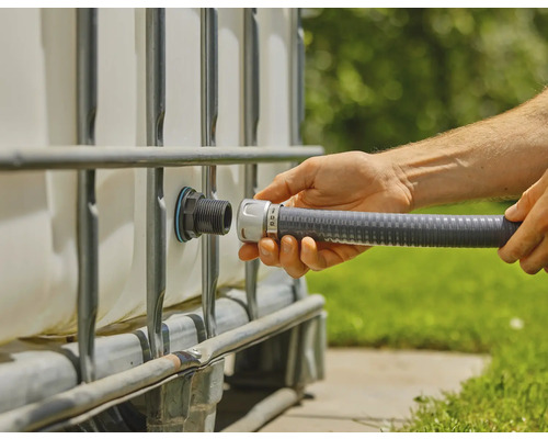 Osoba připojuje flexibilní hadici k IBC kontejneru