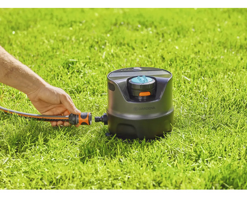 Čtvercový zavlažovač Gardena v provozu s připojením hadice na trávníku