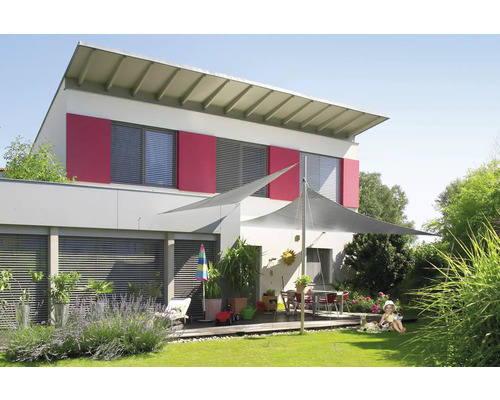 Dům se sluneční plachtou na zahradě pro ochranu před sluncem