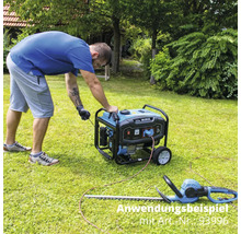 Uživatel spouští generátor na zahradě, nůžky na živý plot leží v trávě.