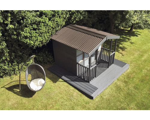 Zahradní domek s terasou a závěsné křeslo na trávníku