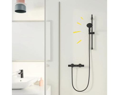 Sprchová armatura s tyčí pro sprchovou hlavici namontovanou na stěně v koupelně.