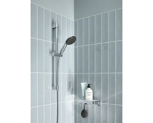 Sprchový kout s ruční sprchou na tyči, polička s kosmetikou a šedé obklady