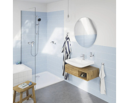 Koupelna se sprchou, umyvadlem a zrcadlem ve světlém a moderním designu.