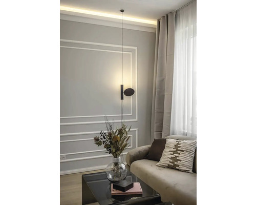 Moderní obývací pokoj s visící lampou, pohovkou, polštáři, konferenčním stolkem a vázou s květinami.
