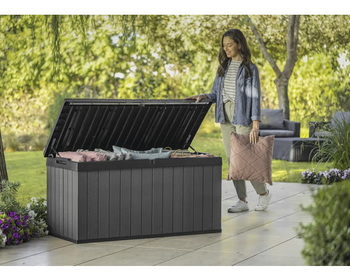 Otevřený plastový zahradní box s polštáři a ženou na zahradě