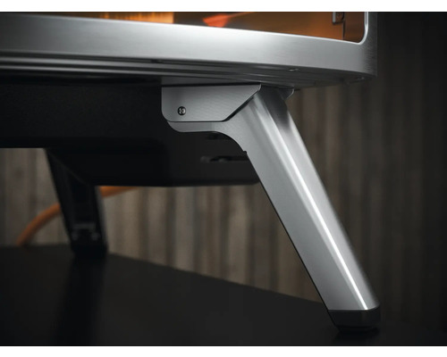 Detailní pohled na pizza pec se stříbrnými kovovými nohami