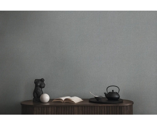 Obývací pokoj se šedou textilní tapetou, komodou, knihou a čajovým servisem