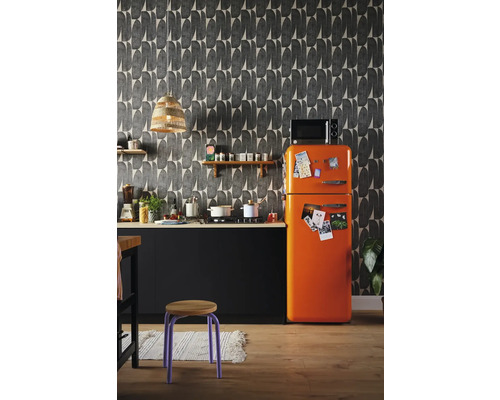 Kuchyňská scéna s černým kuchyňským koutem, oranžovou lednicí a vzorovanou tapetou.