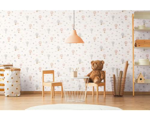 Dětský pokoj s tapetou se vzorem horkovzdušných balónů, stolem, židlemi a hračkami