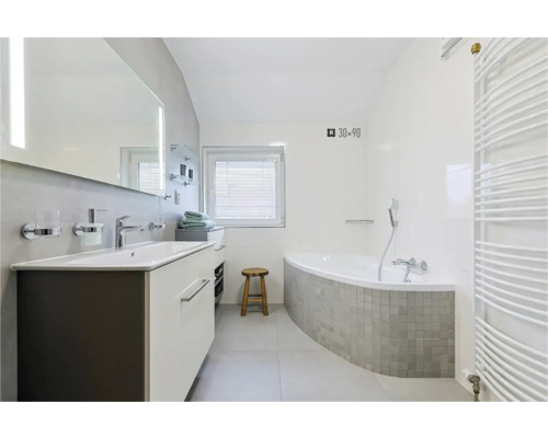 Koupelna s umyvadlem, zrcadlem, vanou a radiátorem